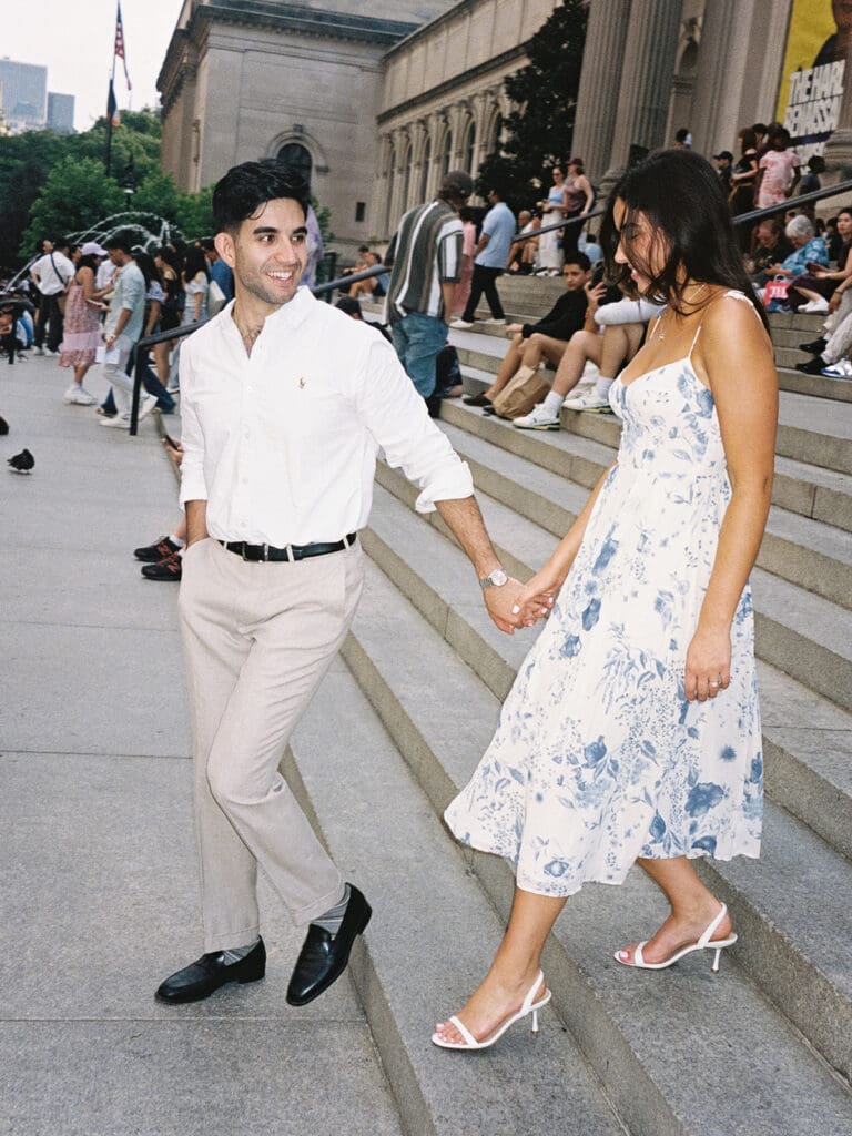 Couple holding hands and walking down the stairs at The Met