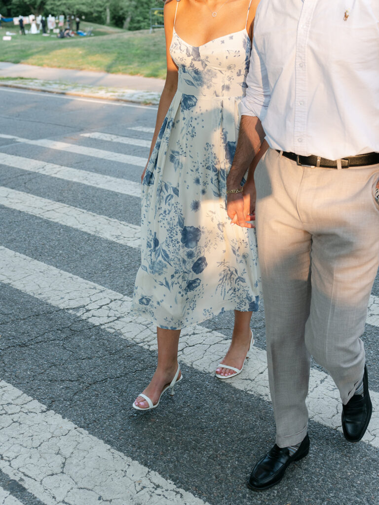 Couple holding hands and walking across the street in New York City