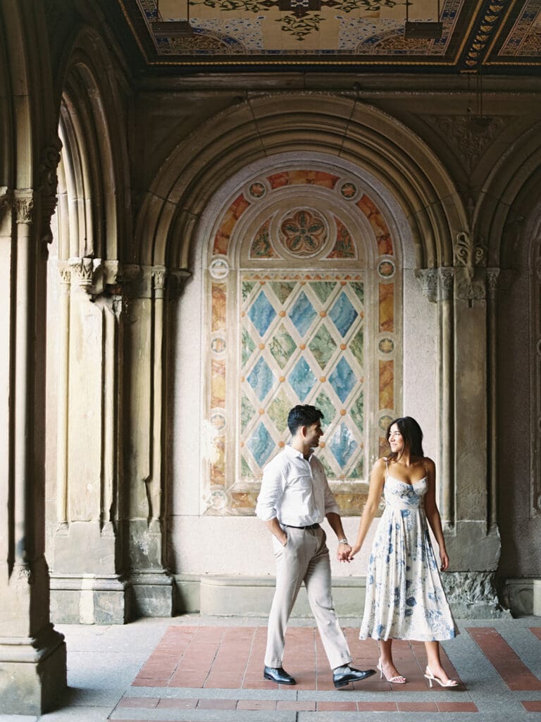 Couple holding hands and walking through Bethesda Terrace
