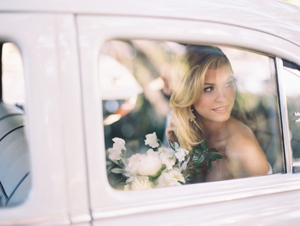 Bride and groom posing in a classic car