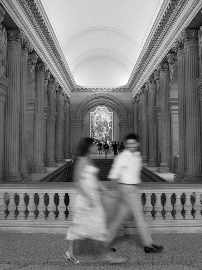 In motion engagement photo of a couple walking at The Met