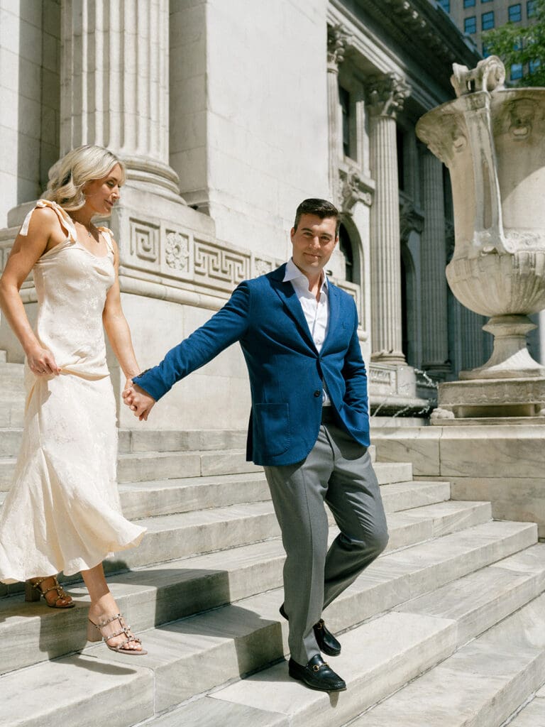 Couple walking down steps during their New York Public Library engagement photos