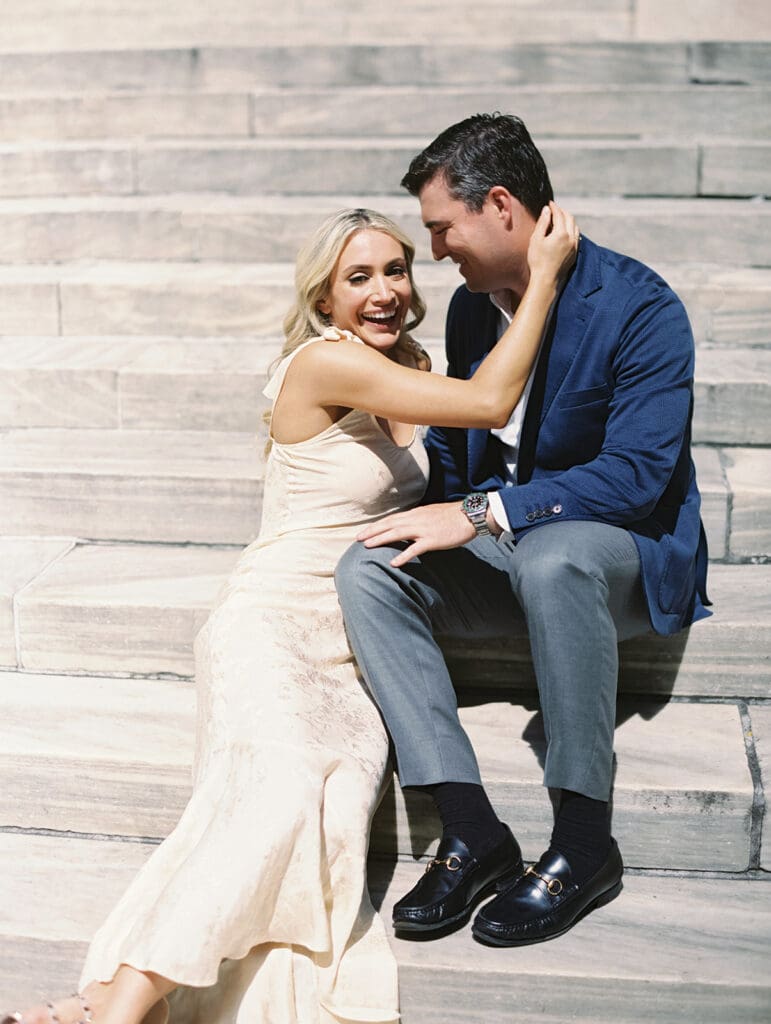 Couple sitting on the steps for their New York Public Library engagement photos