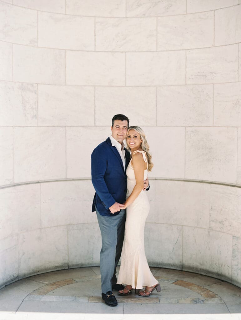 Couple smiling and posing for their New York Public Library engagement photos