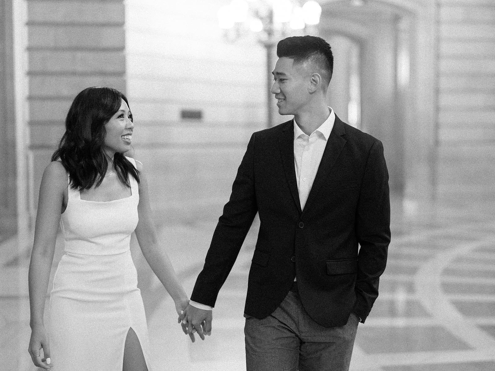 Black and white photo of a couple walking in the San Francisco City Hall