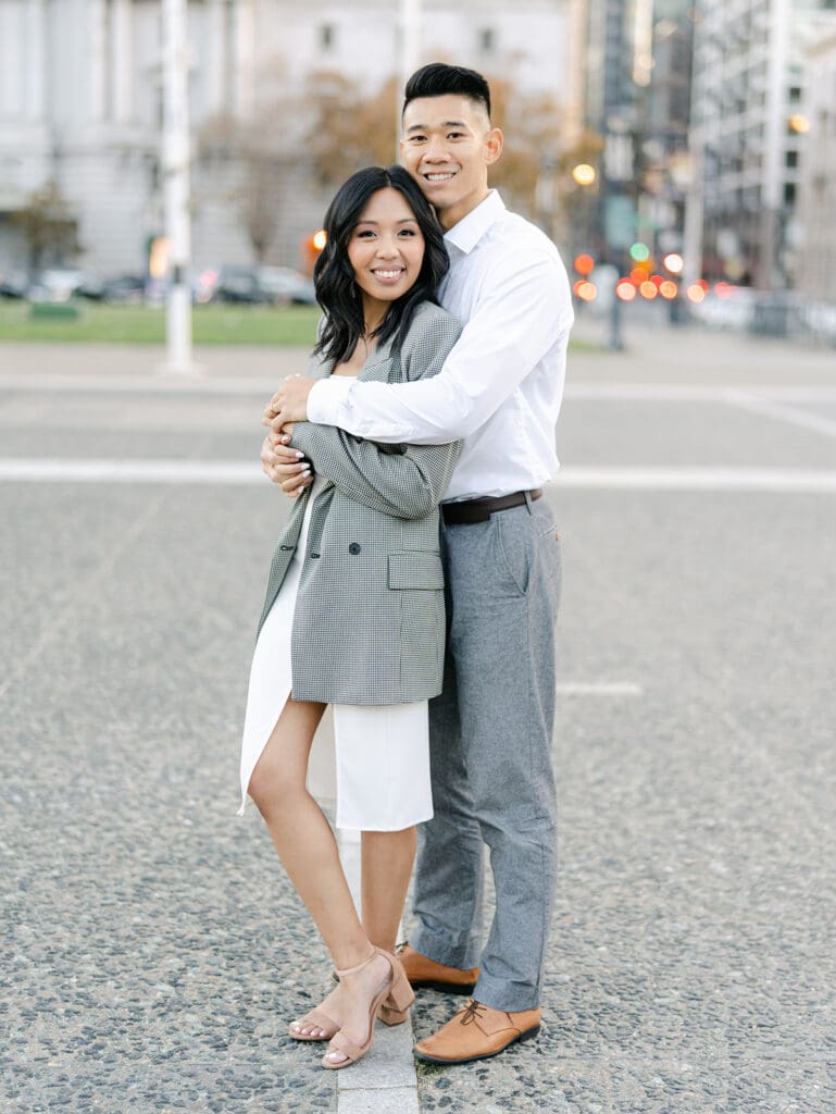 Man and woman posing for their city engagement photos in San Francisco
