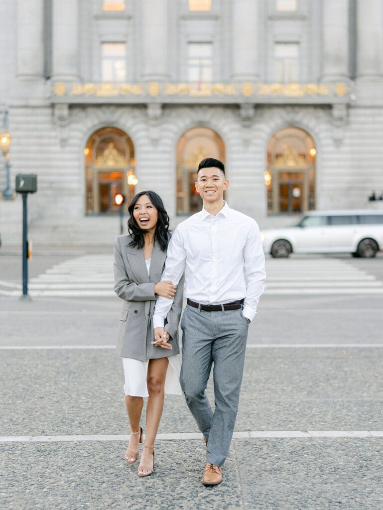 Couple walking and laughing during their outdoor city engagement shoot