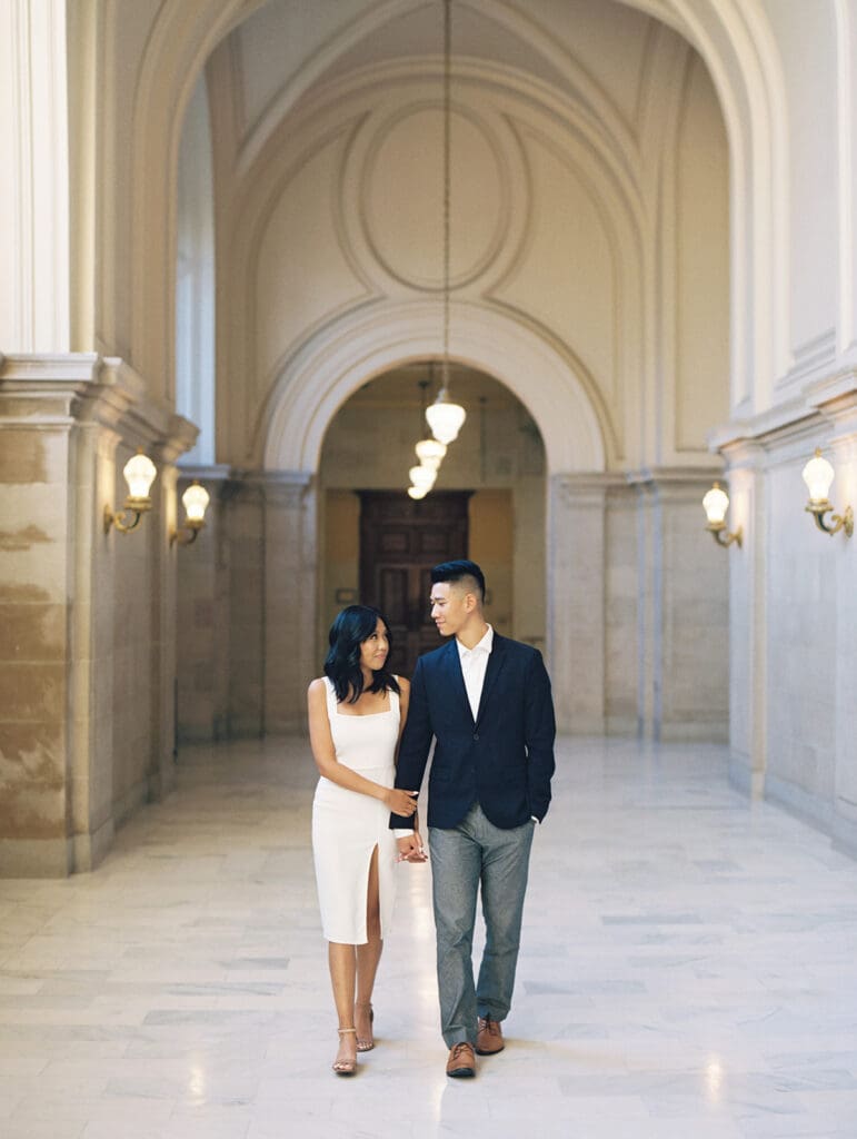 Couple holding hands and walking during their engagement shoot