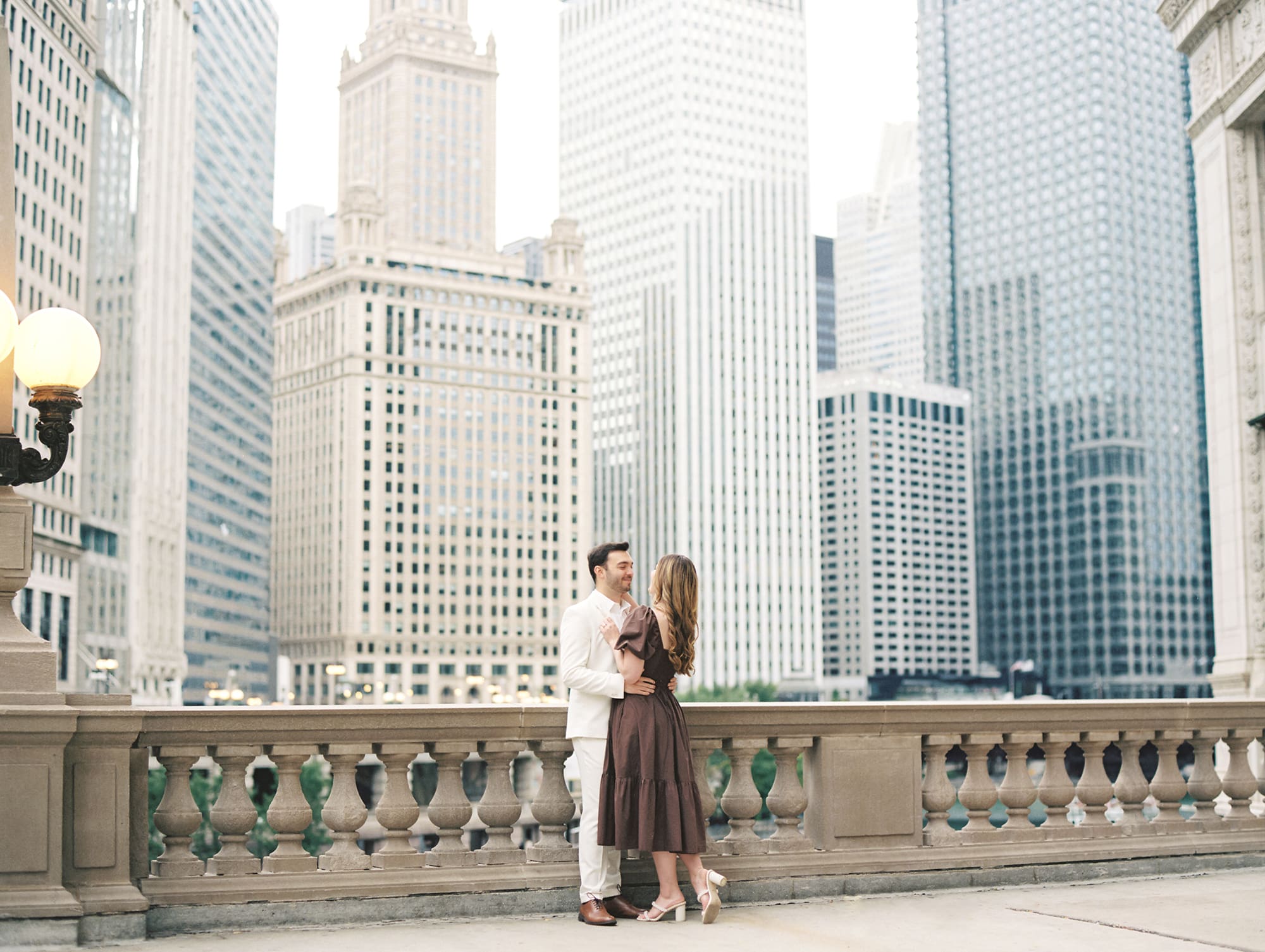Couple embracing during Chicago engagement photos near the Wrigley Building and Chicago River