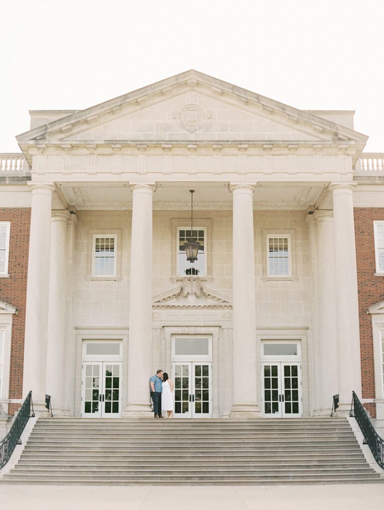 Couple standing on the grand steps of the Chicago History Museum with classic columns and timeless architecture