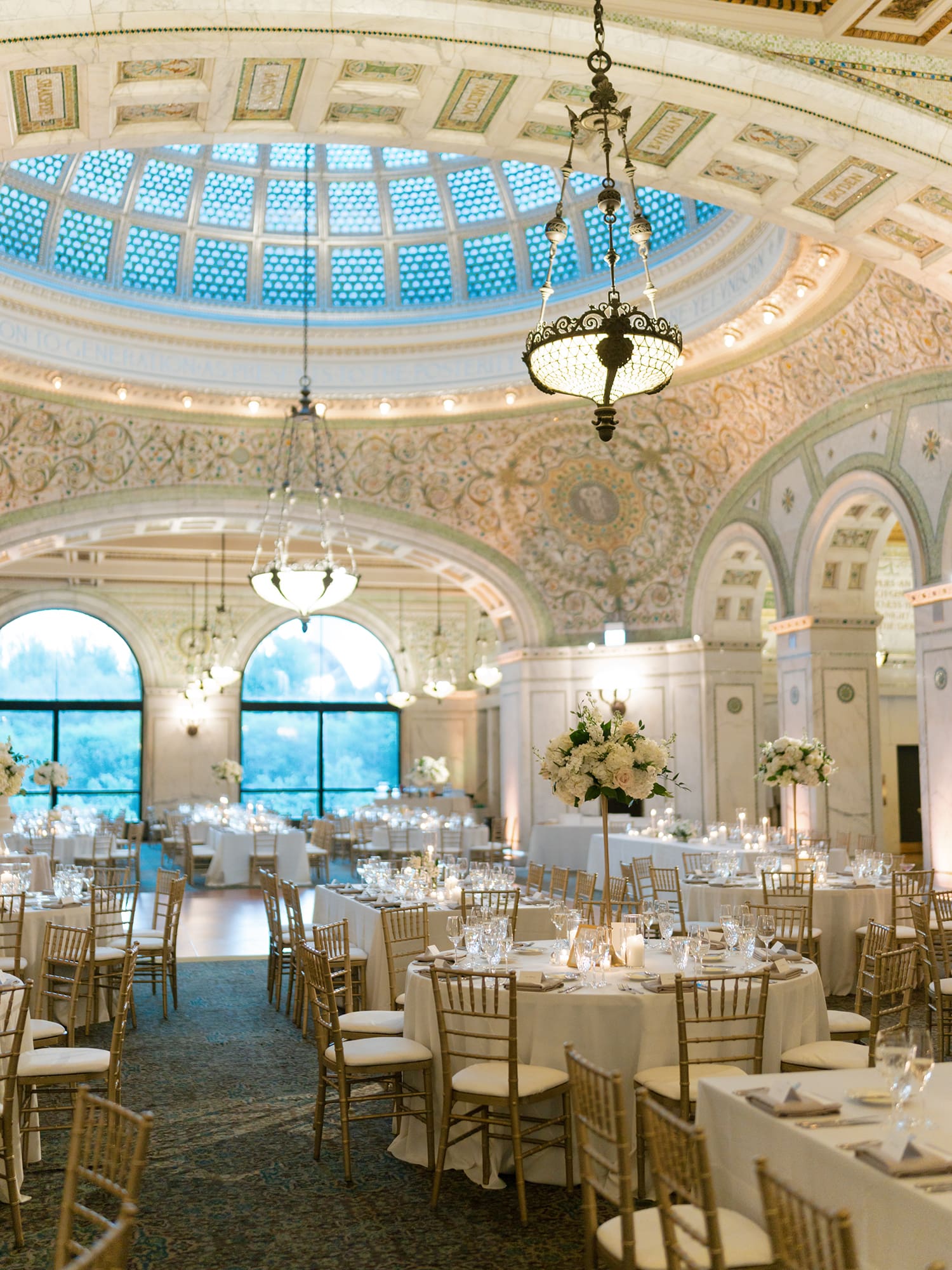 Luxury Chicago wedding venue at the Chicago Cultural Center featuring an elegant reception with domed ceiling, chandeliers, and candlelit tables