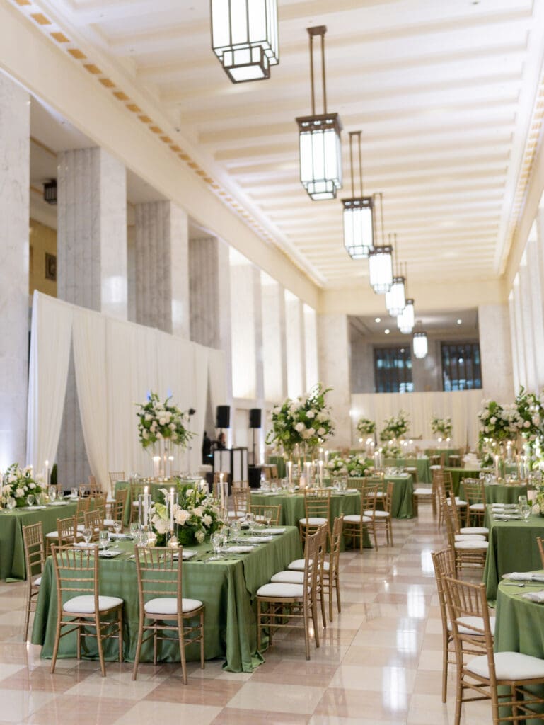 Modern wedding reception at Chicago’s Old Post Office featuring tall ceilings, dramatic lighting, and long banquet tables